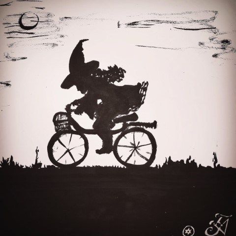 A witch riding a bike in the middle of the night